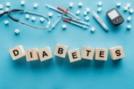 diabetes lettering made of wooden cubes with medical equipment on blue background